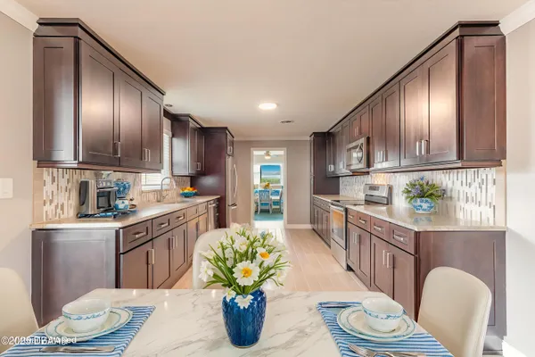 a kitchen with stainless steel appliances granite countertop a refrigerator a stove top oven a sink and cabinets