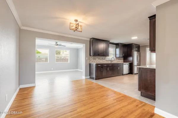 a large kitchen with kitchen island a sink dishwasher stove and oven with wooden floor