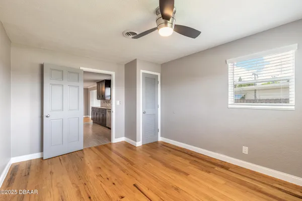 a view of empty room with wooden floor