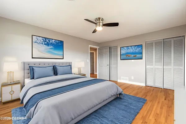 a bedroom with a large bed and a ceiling fan