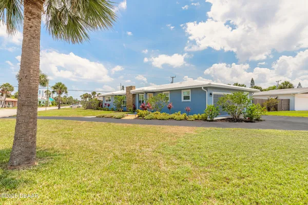 a front view of house with yard and ocean view
