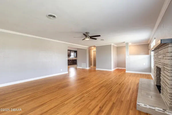 a view of empty room with wooden floor