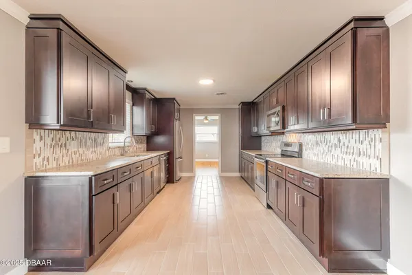 a kitchen with stainless steel appliances granite countertop wooden cabinets a sink and dishwasher