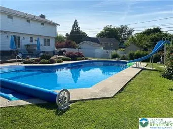 a view of a swimming pool with a patio and a garden
