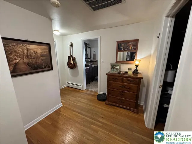 a view of a hallway with wooden floor and closet