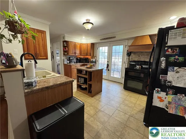 a kitchen with stainless steel appliances kitchen island granite countertop a stove and a sink