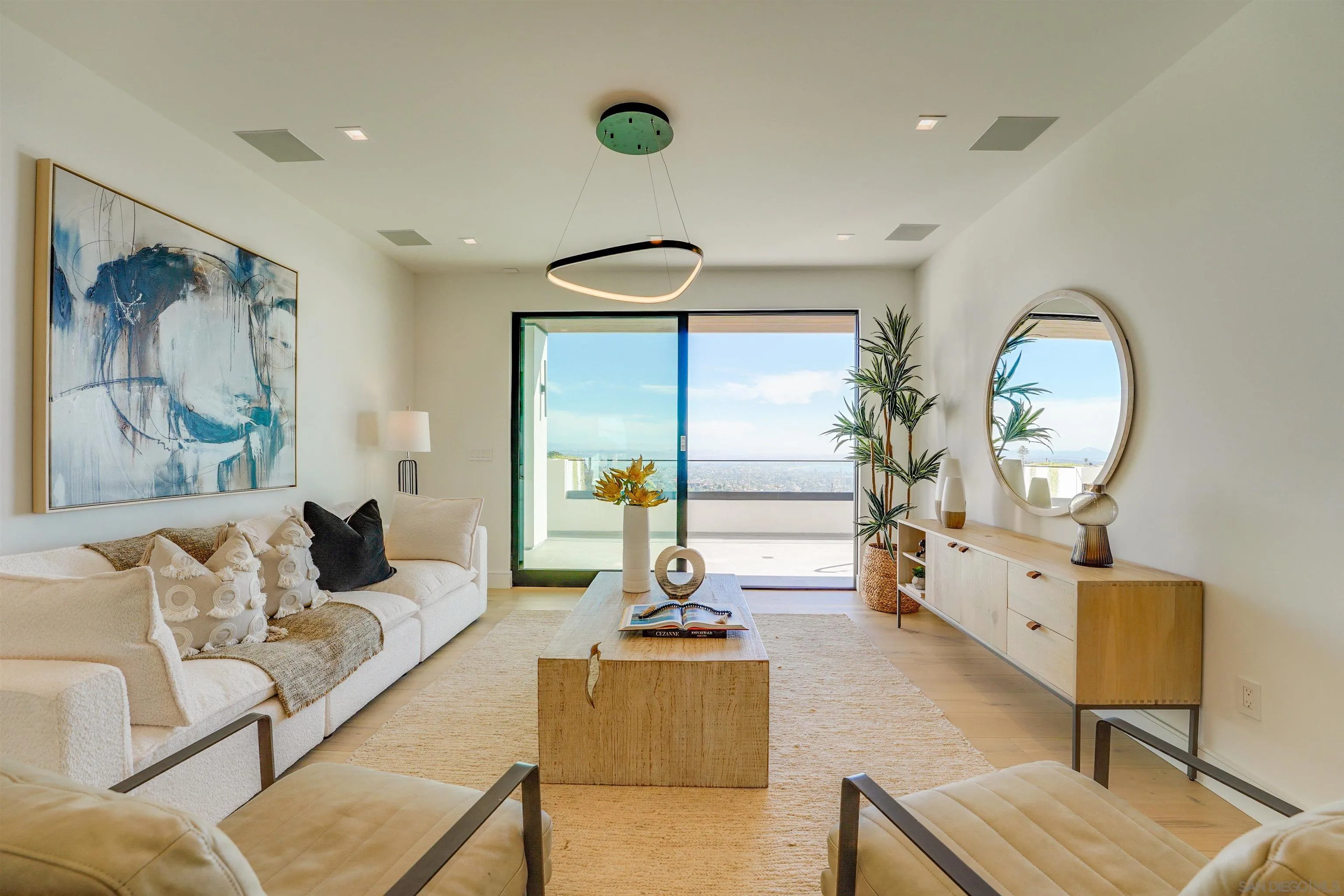 1205 La Jolla Rancho Road La Jolla, CA 92037 - Photo 32 of 75 a living room with furniture a mirror and a chandelier