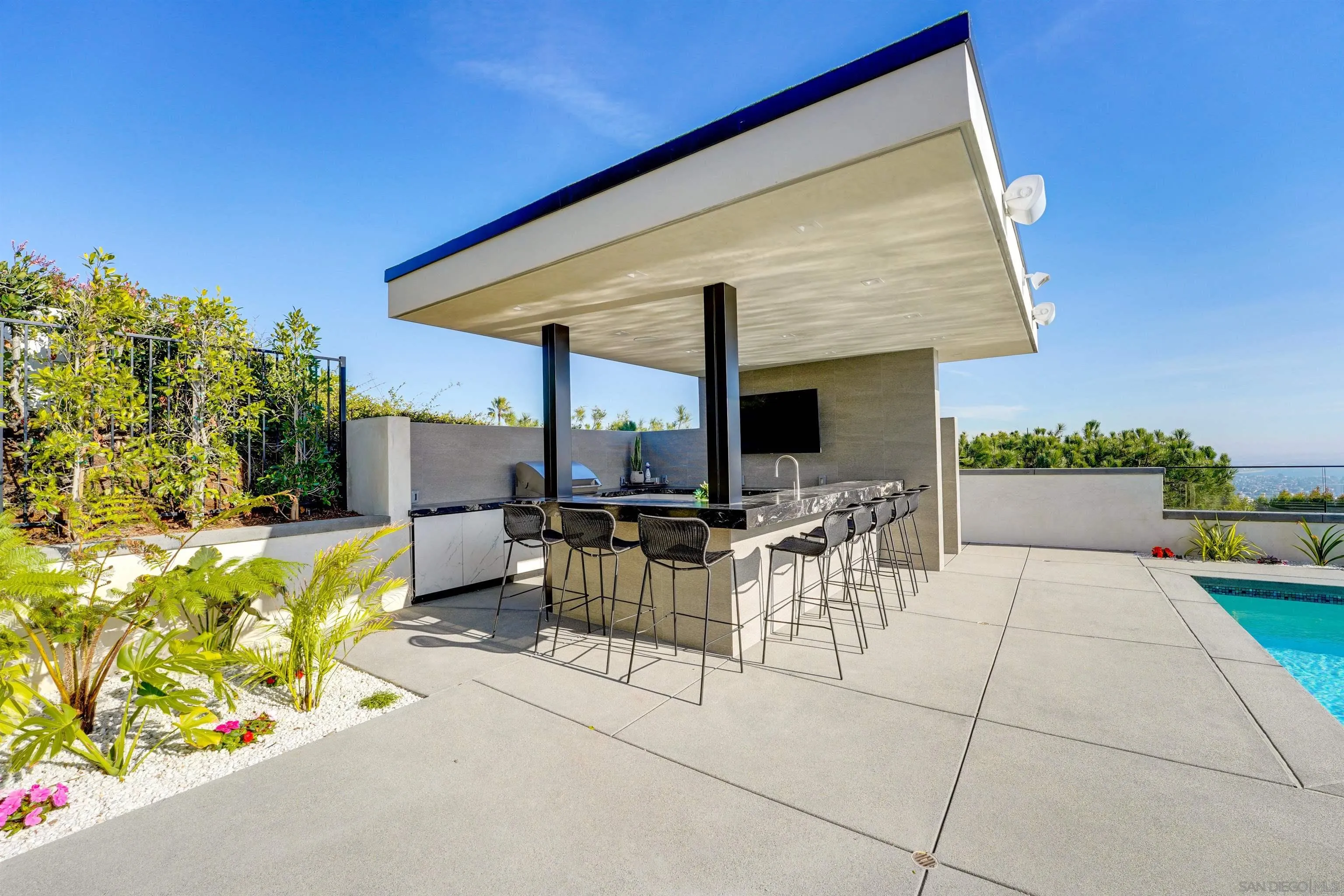 1205 La Jolla Rancho Road La Jolla, CA 92037 - Photo 56 of 75 a view of a patio with couches table and chairs under an umbrella