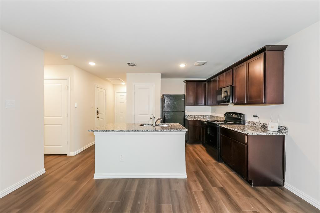 609 Sherman Street Waco, TX 76704 - Photo 2 of 21 a kitchen with stainless steel appliances granite countertop a stove top oven a sink dishwasher a refrigerator and a cabinets with wooden floor