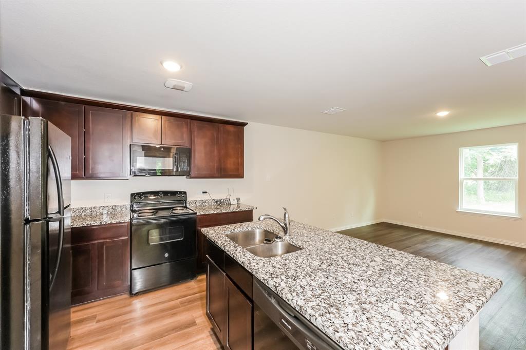 609 Sherman Street Waco, TX 76704 - Photo 3 of 21 a kitchen with stainless steel appliances granite countertop a sink stove refrigerator and cabinets