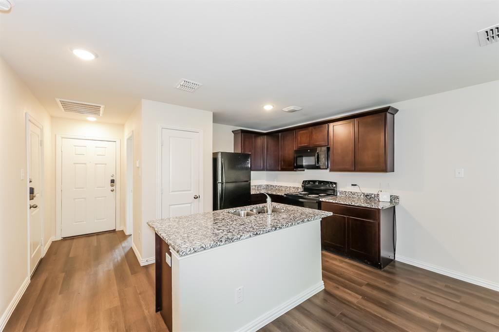 609 Sherman Street Waco, TX 76704 - Photo 4 of 21 a kitchen with stainless steel appliances granite countertop a stove top oven a refrigerator a sink and dishwasher with wooden floor