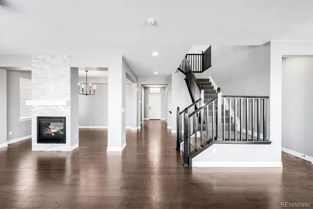 a hallway with wooden floor fireplace and windows