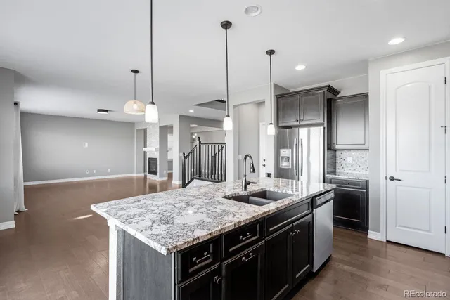 a kitchen with stainless steel appliances granite countertop stove a refrigerator and a sink
