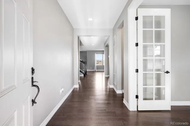 a view of a hallway with wooden floor and closet