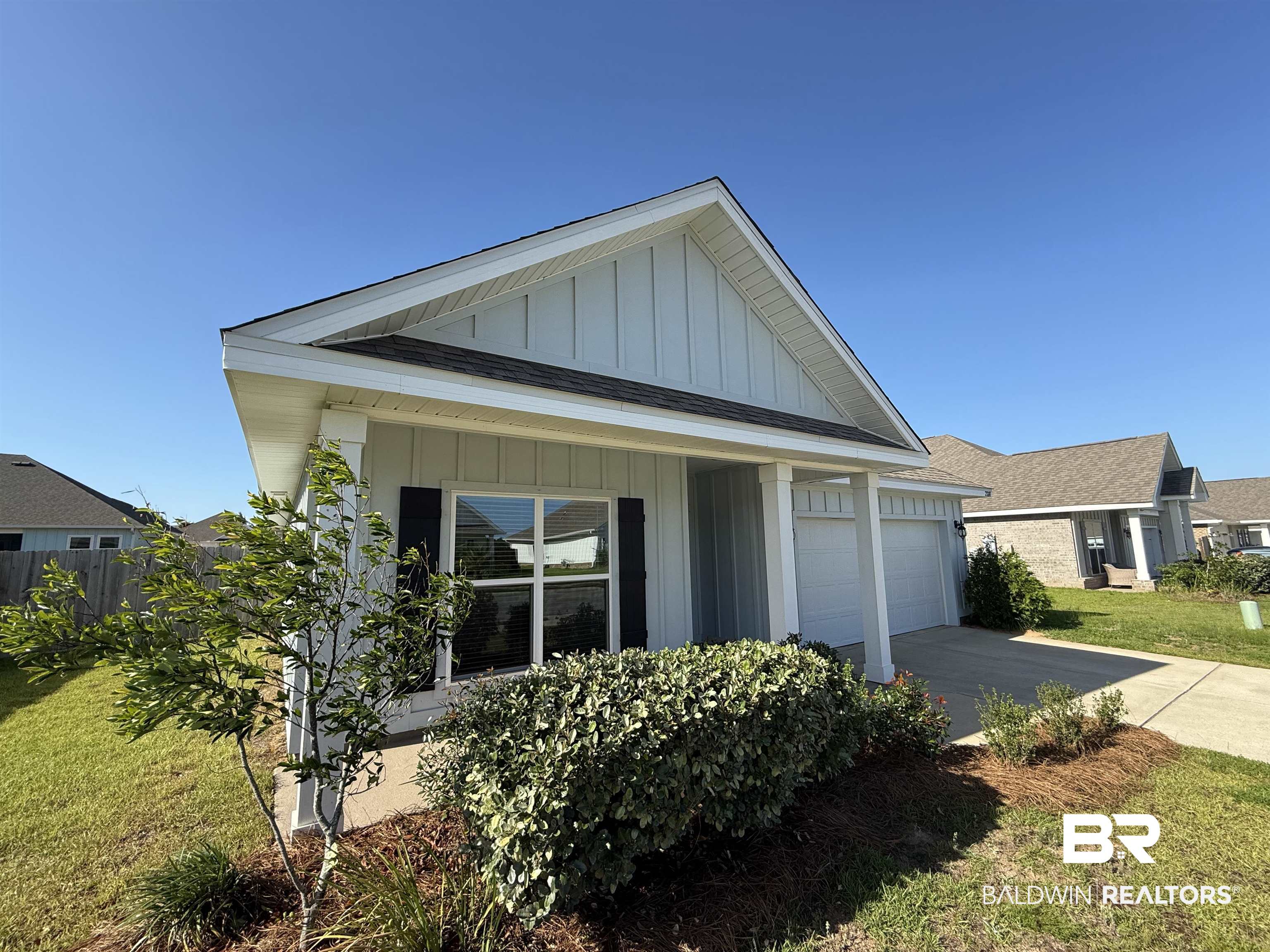 23247 Lieutenant Avenue Foley, AL 36535 - Photo 1 of 47 Contemporary single-story residence featuring light-colored siding, a dark shingled roof, and a prominent front gable