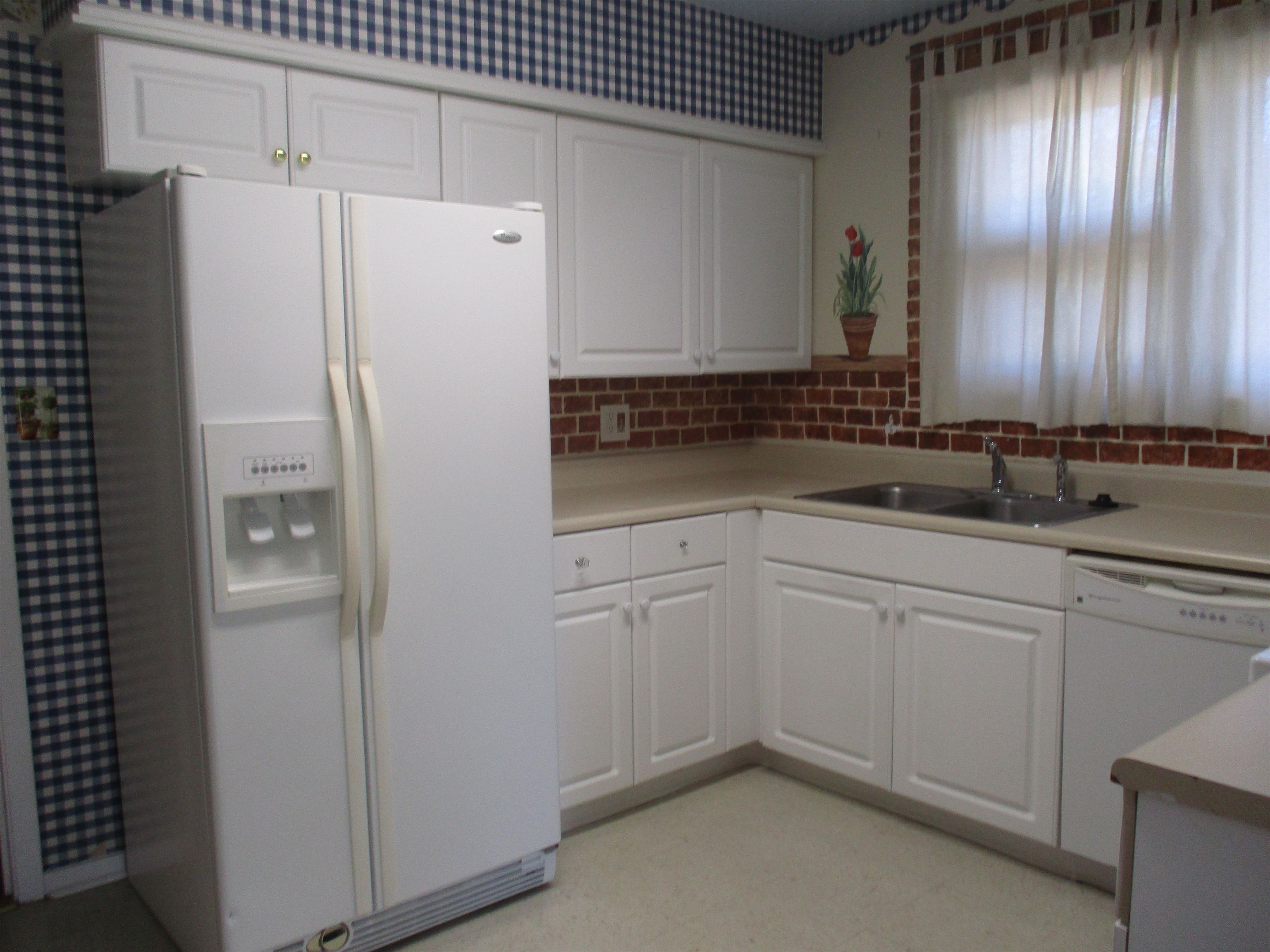 3752 Tea Rose Street, Unit 3752 Myrtle Beach, SC 29577 - Photo 3 of 8 Kitchen with white appliances, white cabinetry, light countertops, light floors, and backsplash