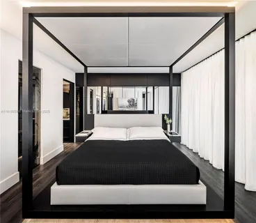 a large bed in a bedroom next to a window