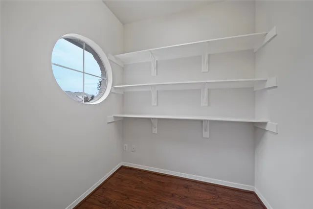 an empty room with a wooden floor and white cabinet
