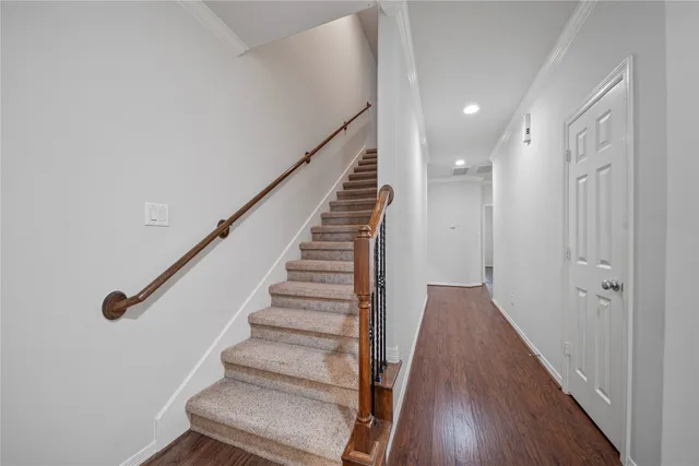 a view of a hallway with wooden floor and entryway