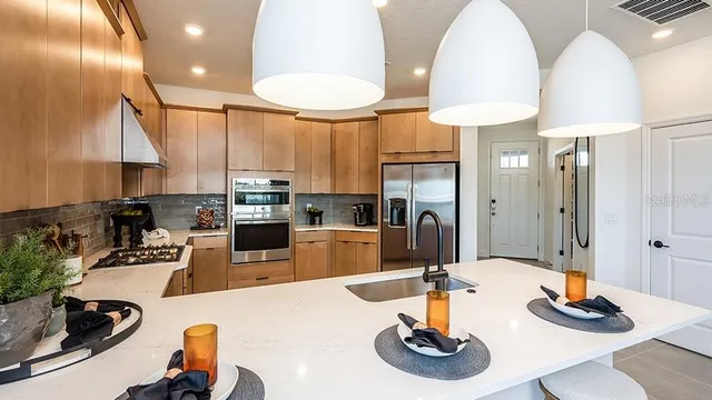 a kitchen with stainless steel appliances granite countertop a sink a stove and a refrigerator