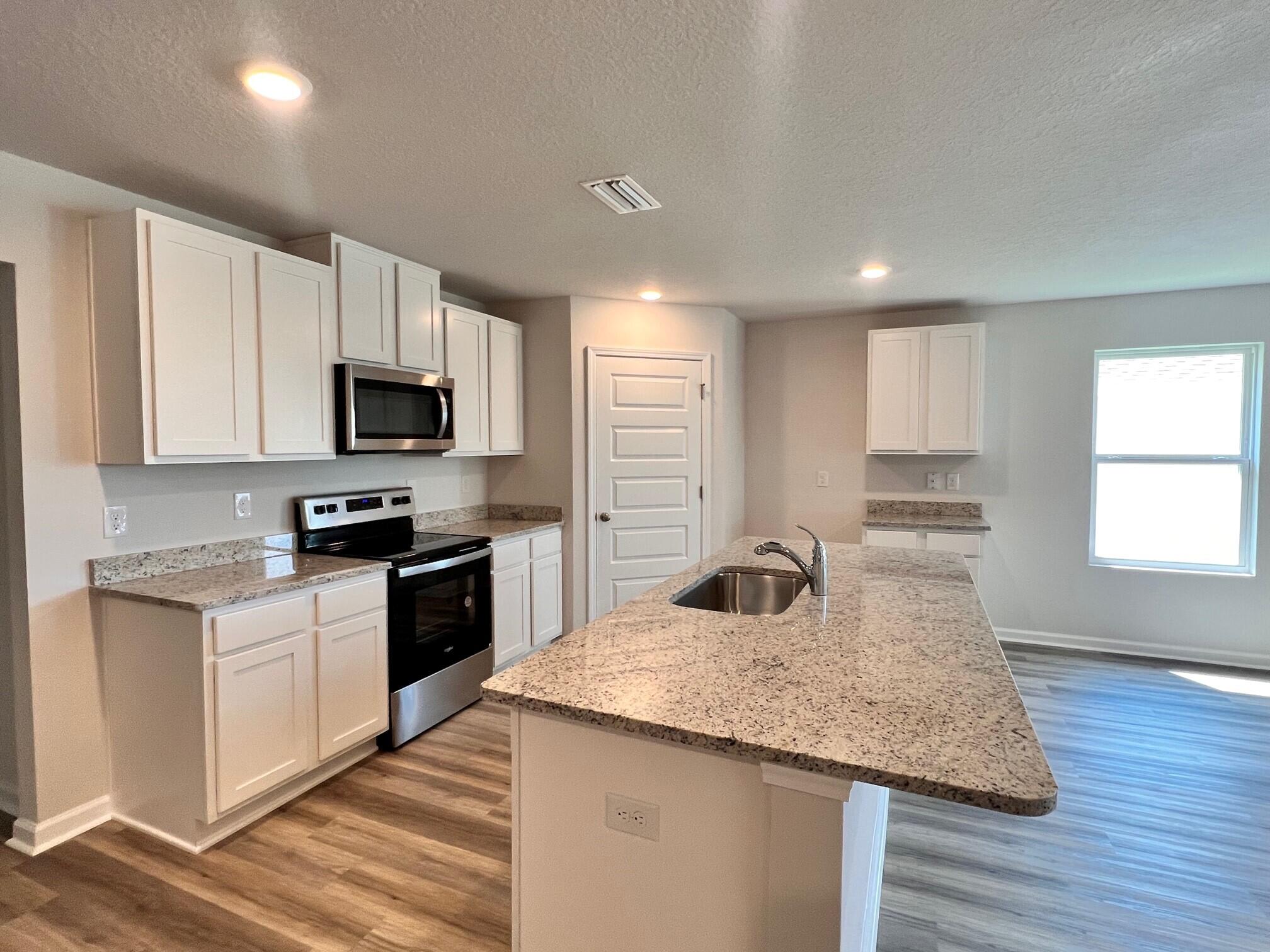 3021 Jane Lane Crestview, FL 32539 - Photo 5 of 16 a kitchen with granite countertop a sink a counter space appliances and cabinets