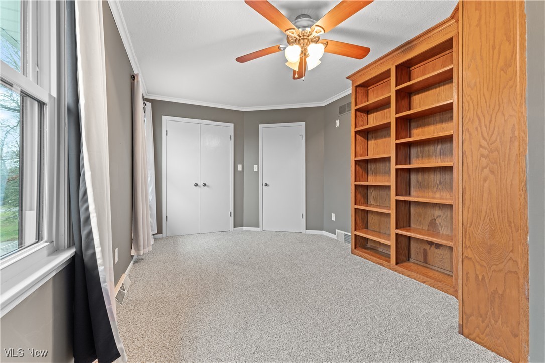 645 Killinger Road Clinton, OH 44216 - Photo 37 of 50 Unfurnished bedroom with carpet floors, a closet, ceiling fan, and ornamental molding