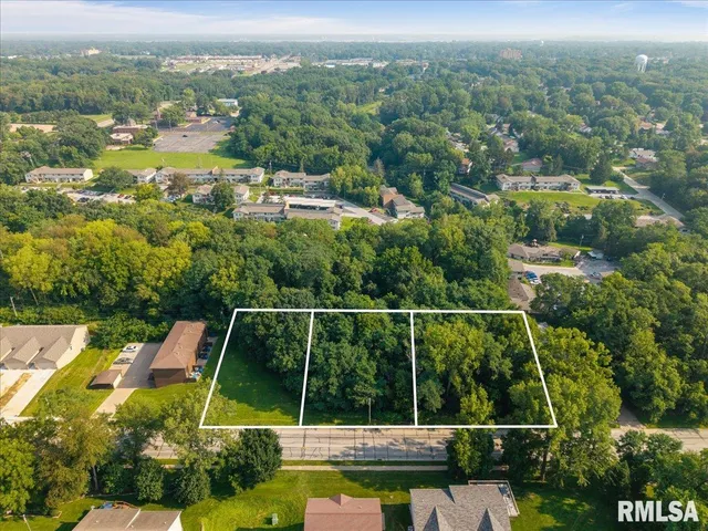 an aerial view of residential houses with outdoor space and trees