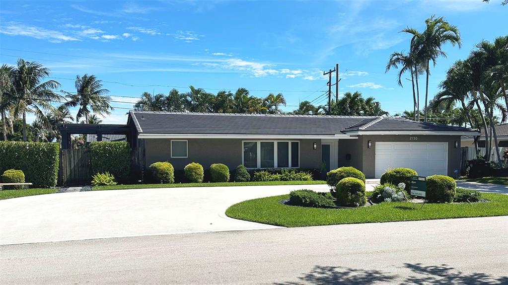 a front view of a house with a yard and potted plants