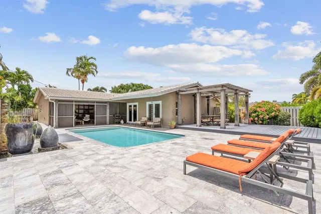 a view of a house with a swimming pool and sitting area