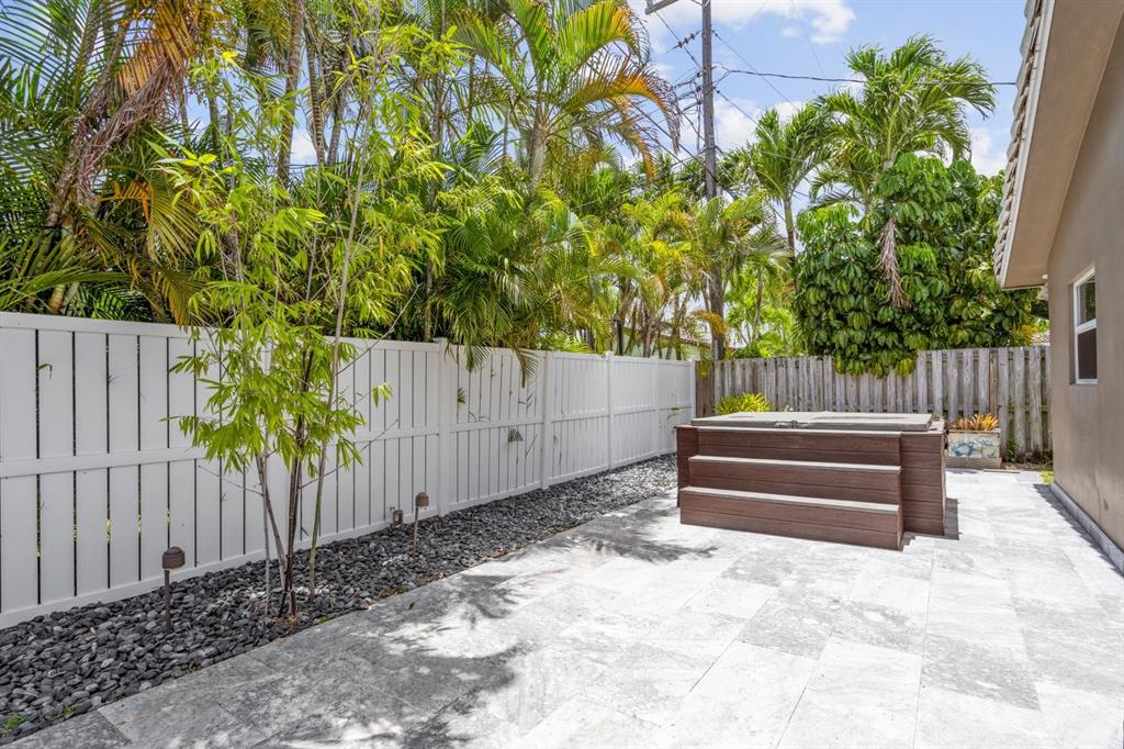 2750 Northeast 45th Street Lighthouse Point, FL 33064 - Photo 18 of 21 a backyard of a house with wooden fence and trees