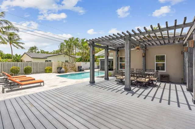 a view of a patio with dining table and chairs with wooden floor