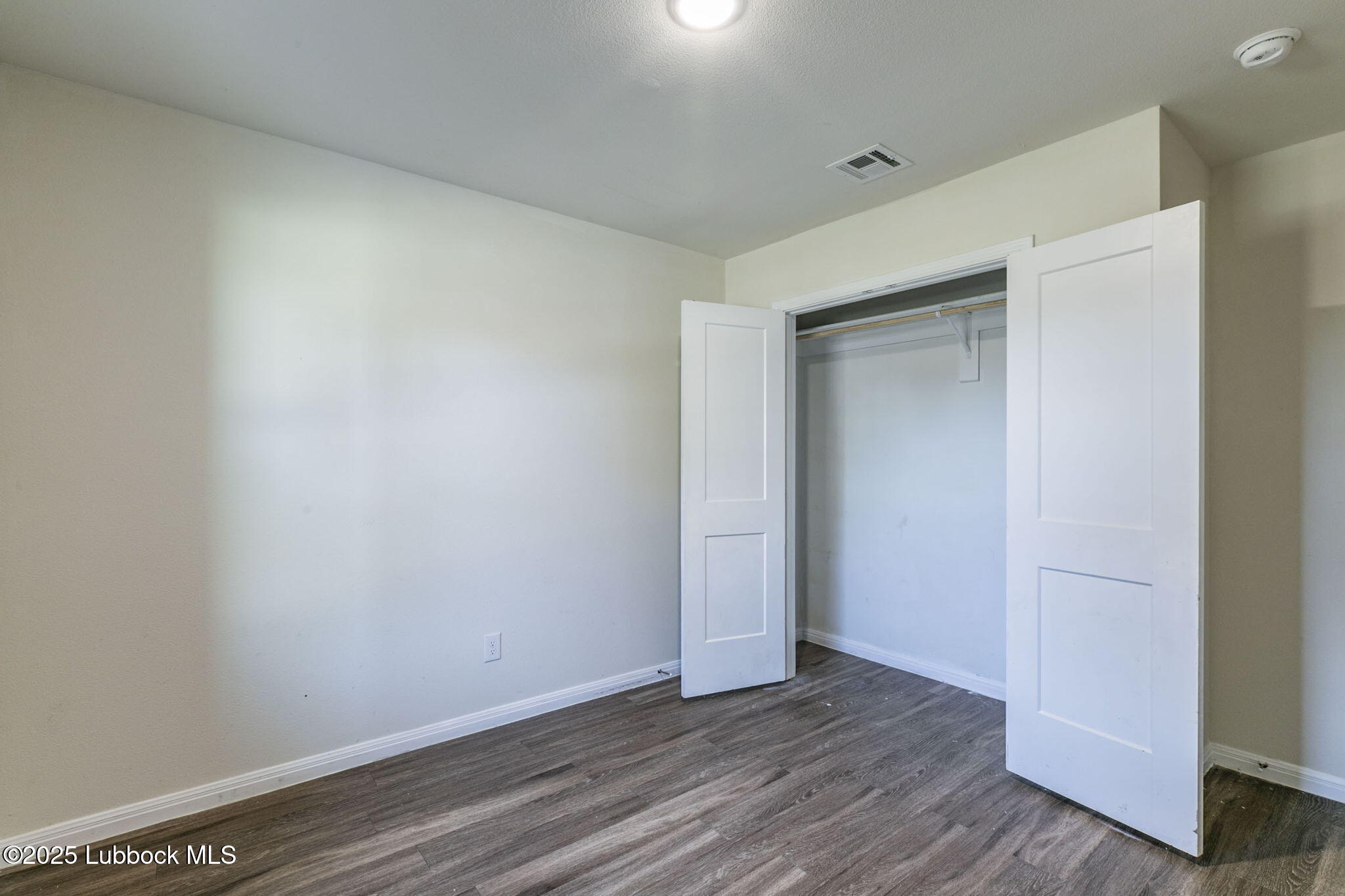 1714 East Cornell Street Lubbock, TX 79403 - Photo 11 of 18 a view of an empty room with wooden floor and closet