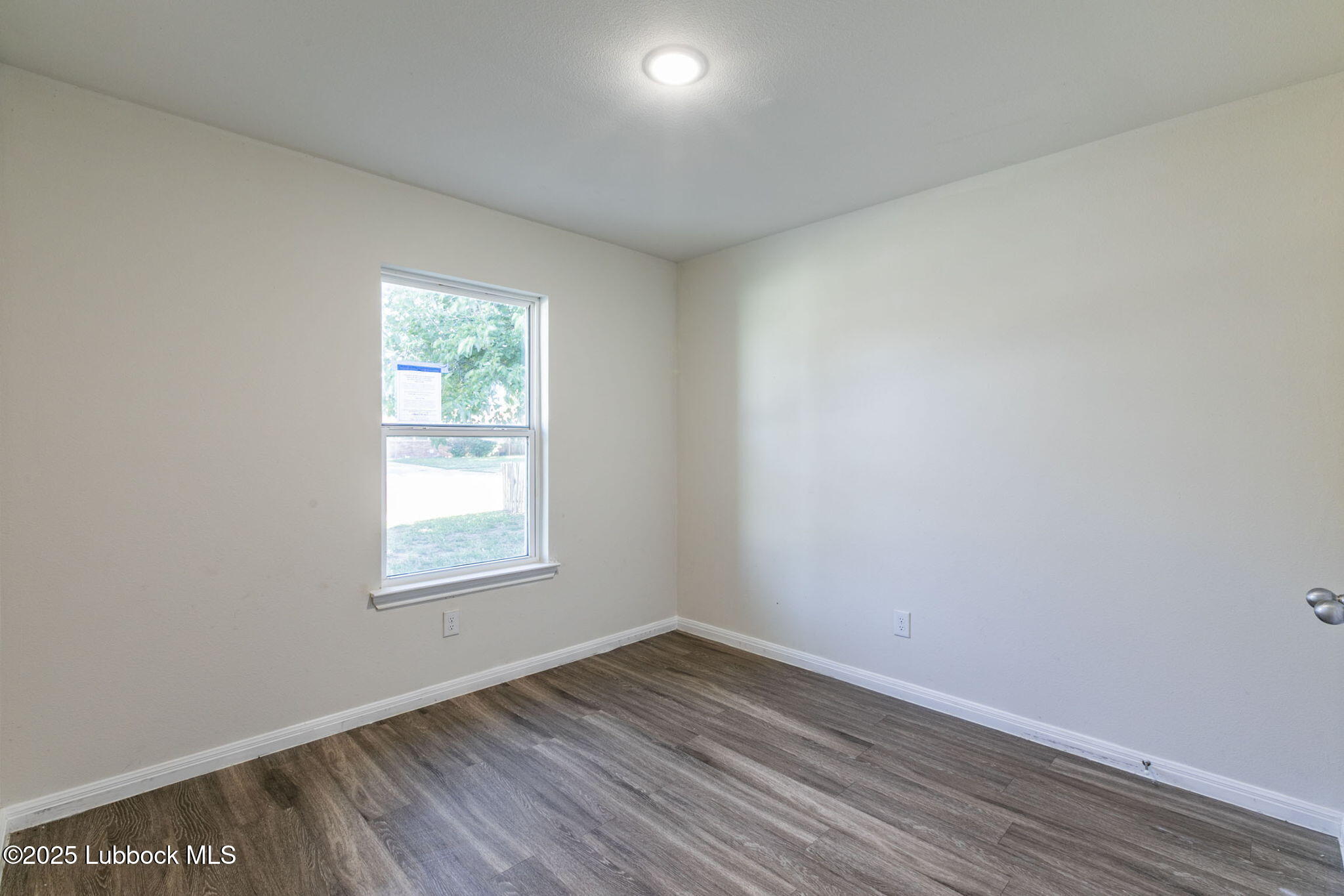 1714 East Cornell Street Lubbock, TX 79403 - Photo 12 of 18 an empty room with wooden floor and windows