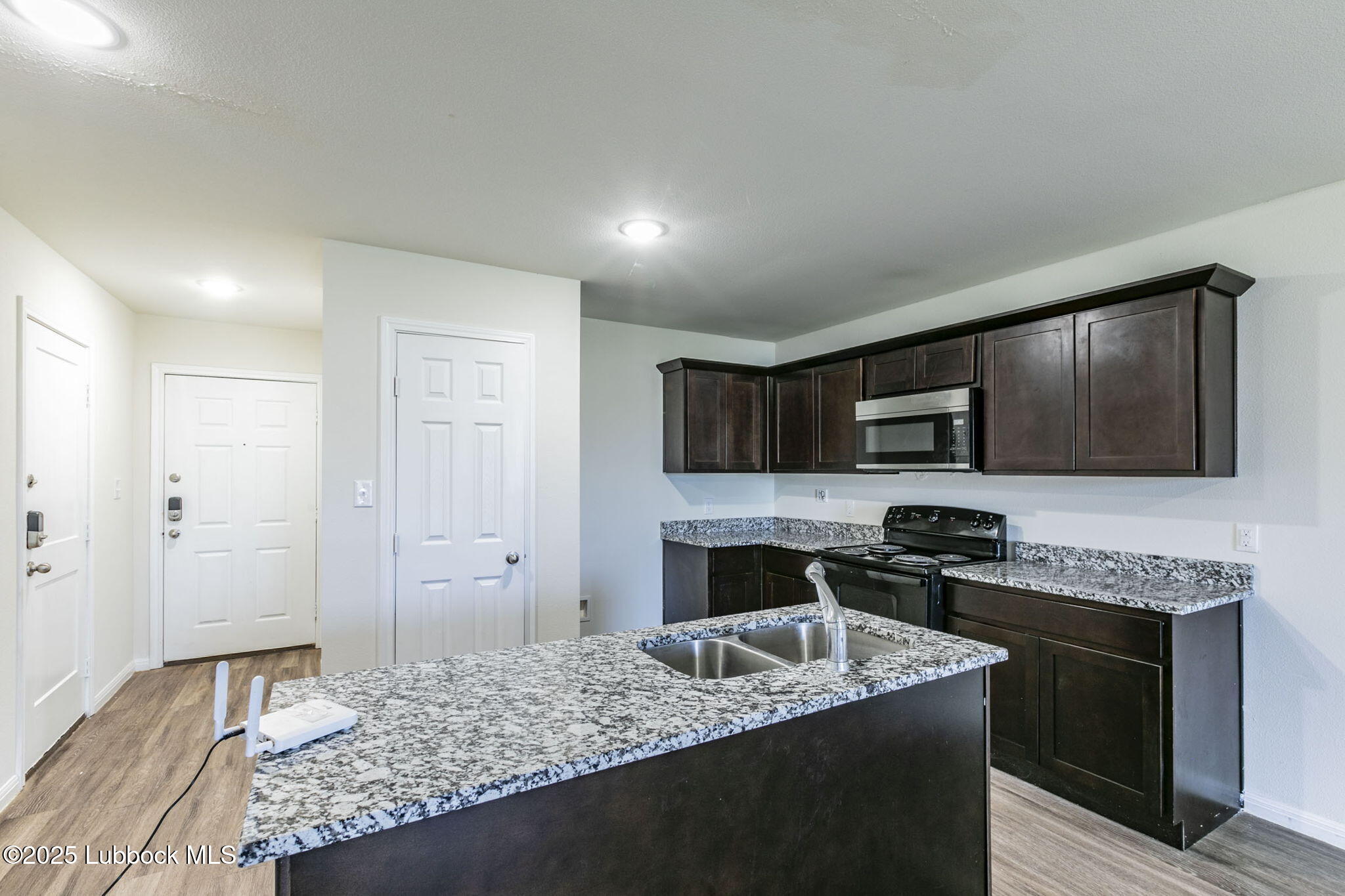 1714 East Cornell Street Lubbock, TX 79403 - Photo 6 of 18 a kitchen with granite countertop cabinets stove top oven and sink