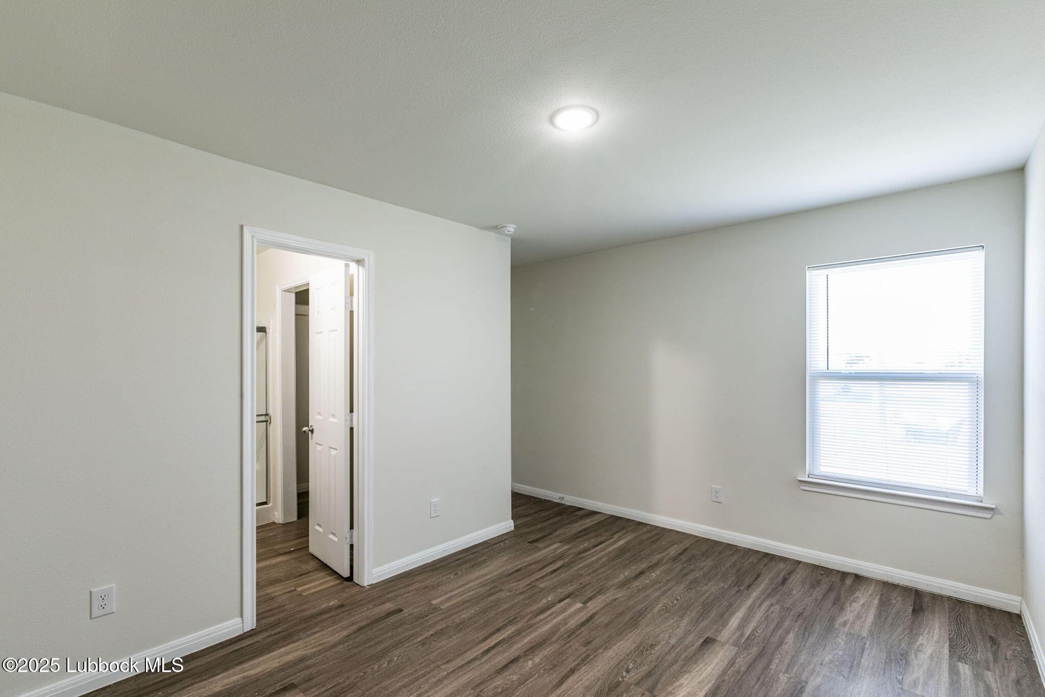 1714 East Cornell Street Lubbock, TX 79403 - Photo 9 of 18 an empty room with wooden floor and windows