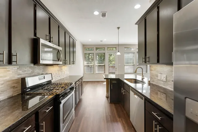 a kitchen with stainless steel appliances granite countertop a stove and a sink