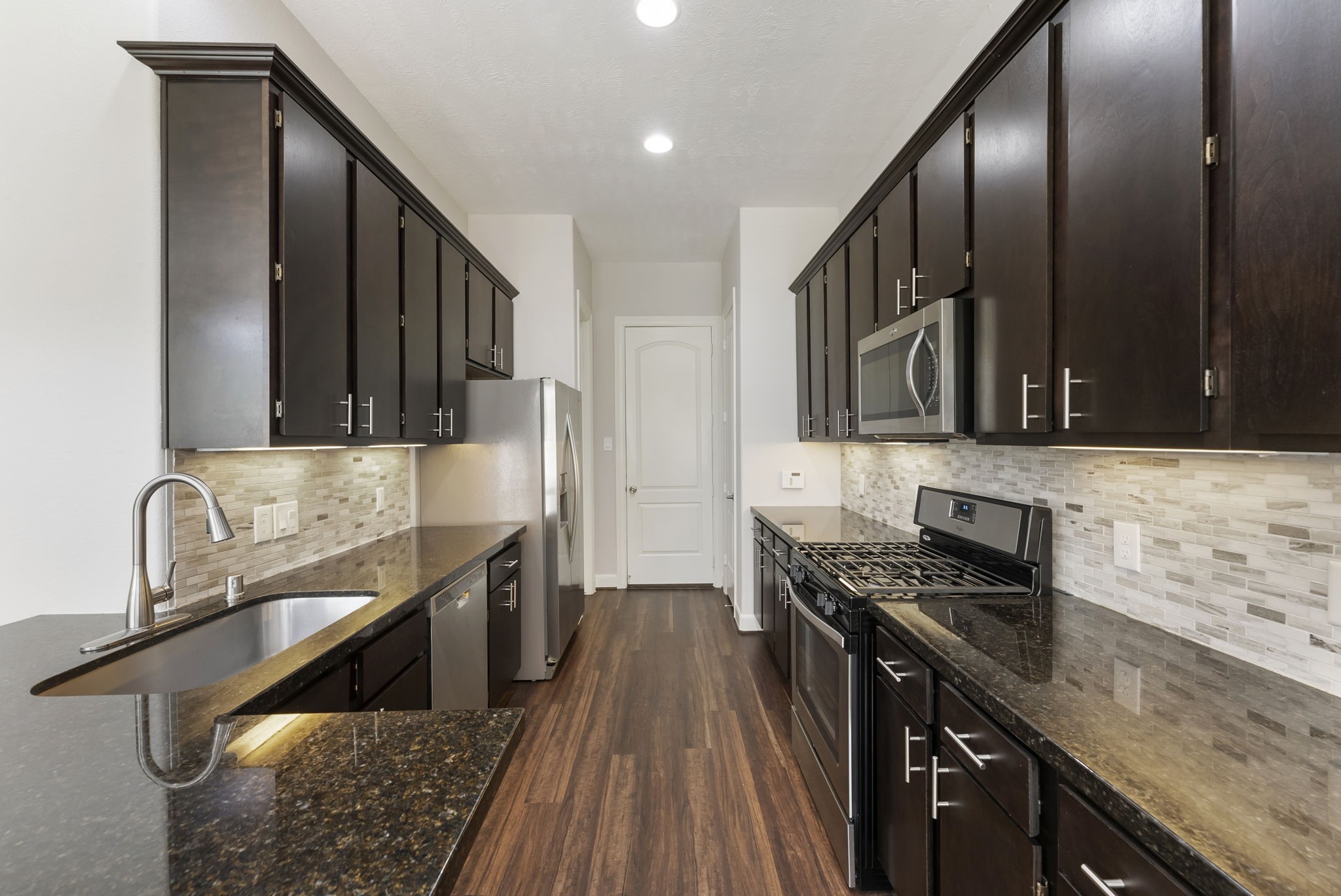 31 Aventura Place Spring, TX 77389 - Photo 16 of 49 a kitchen with stainless steel appliances granite countertop a sink stove and cabinets