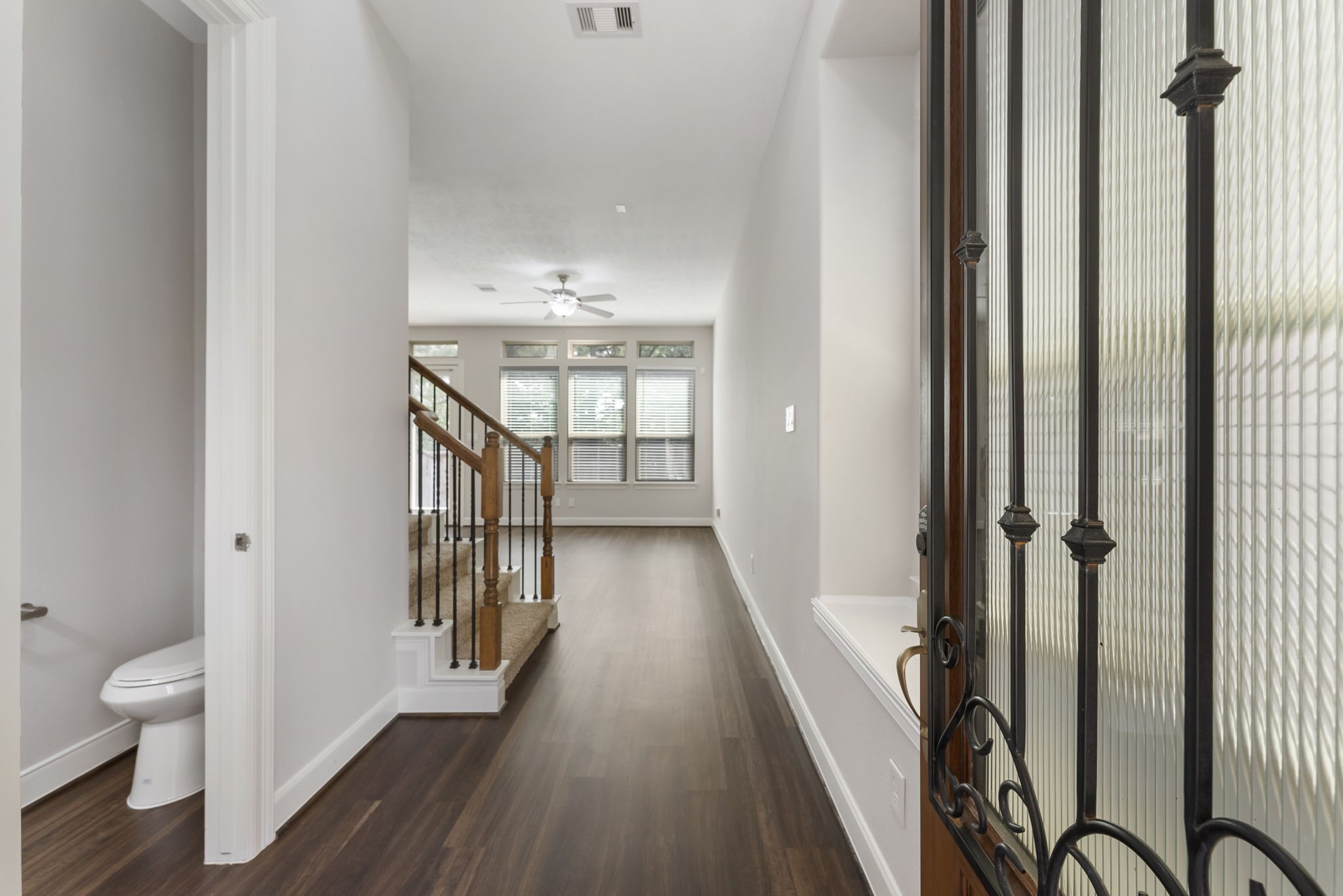 31 Aventura Place Spring, TX 77389 - Photo 3 of 49 a view of a hallway with wooden floor and a bathroom