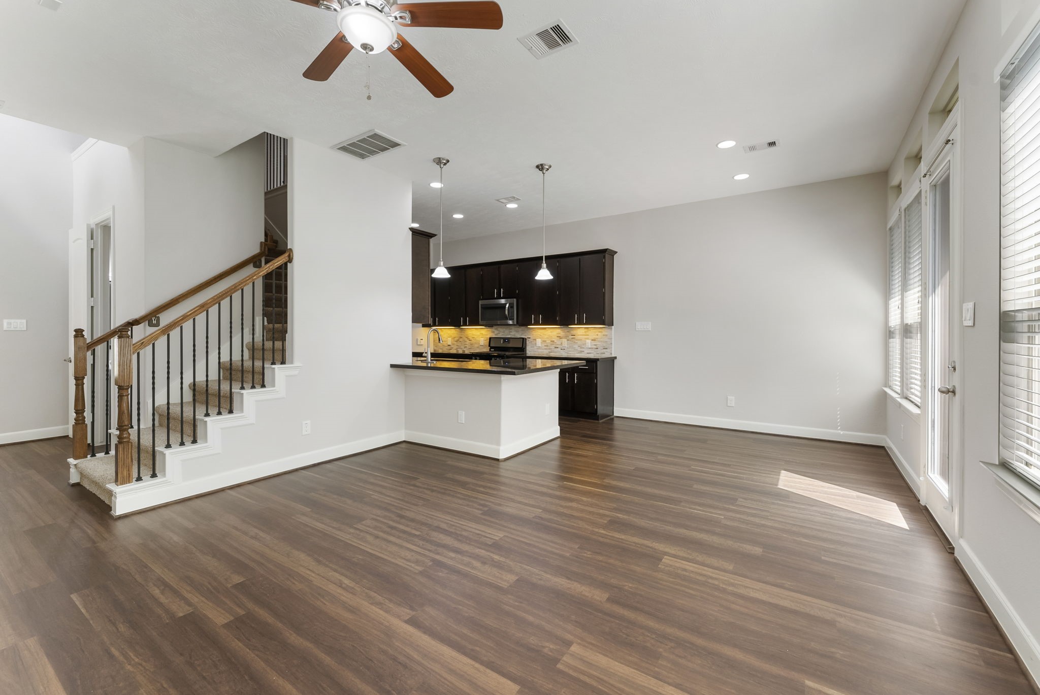 31 Aventura Place Spring, TX 77389 - Photo 6 of 49 a view of an empty room with wooden floor and a ceiling fan