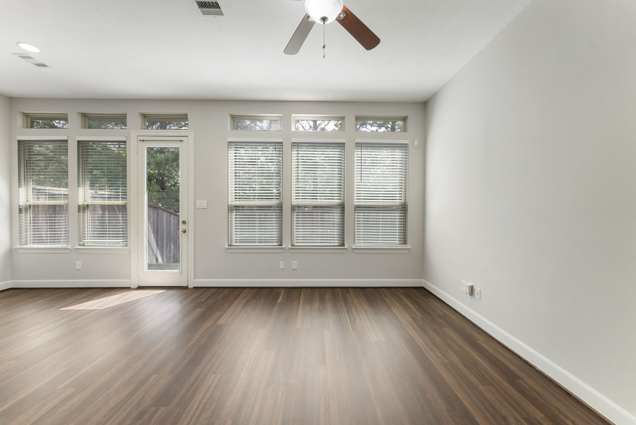 31 Aventura Place Spring, TX 77389 - Photo 8 of 49 a view of an empty room with wooden floor and a window