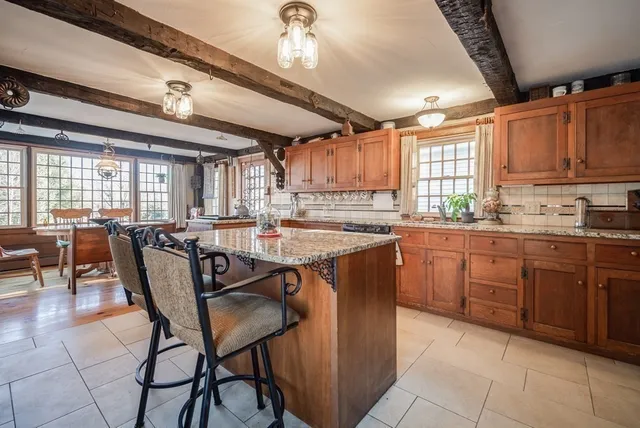 a kitchen with stainless steel appliances granite countertop table chairs sink and cabinets