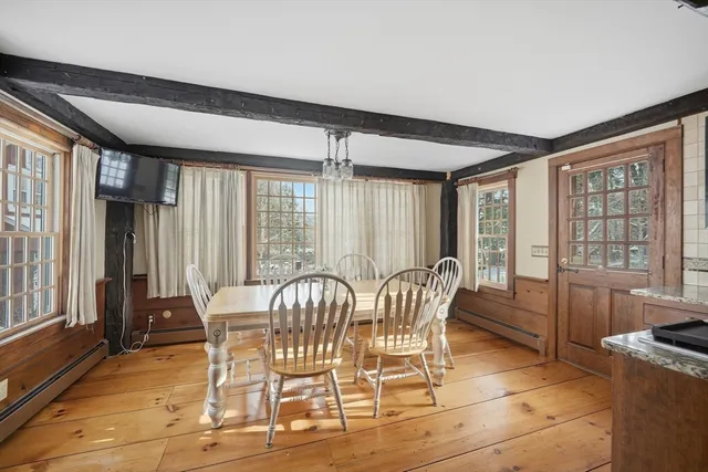 a view of a dining room with furniture large windows and wooden floor