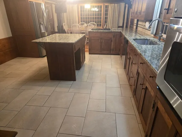 a spacious bathroom with a granite countertop sink a mirror and bathtub