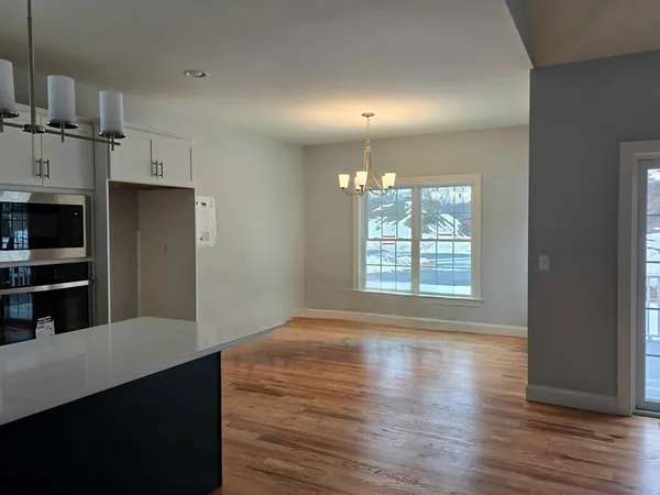 a kitchen with stainless steel appliances a refrigerator and a wooden floor
