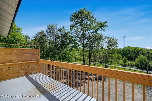 a view of a balcony with wooden floor and fence