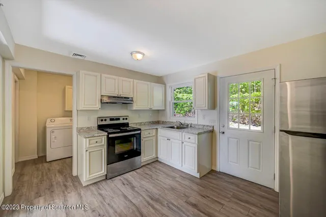 a kitchen with a stove a sink and a refrigerator