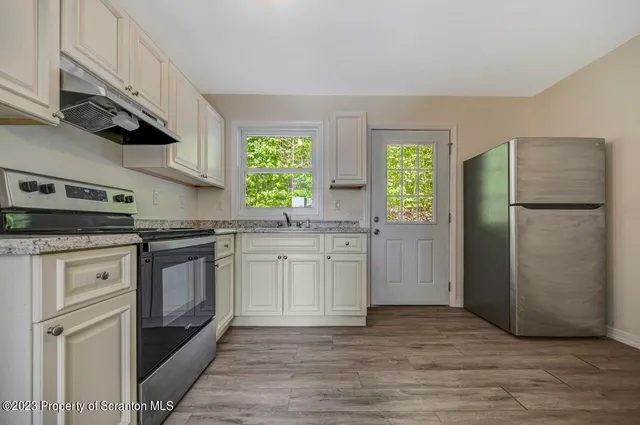 a kitchen with white cabinets and appliances