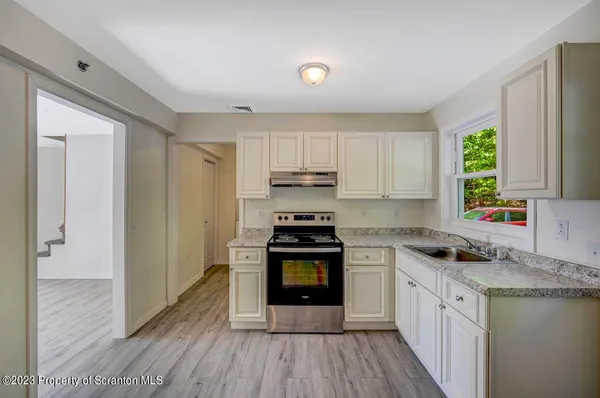 a kitchen with a stove a sink and a microwave