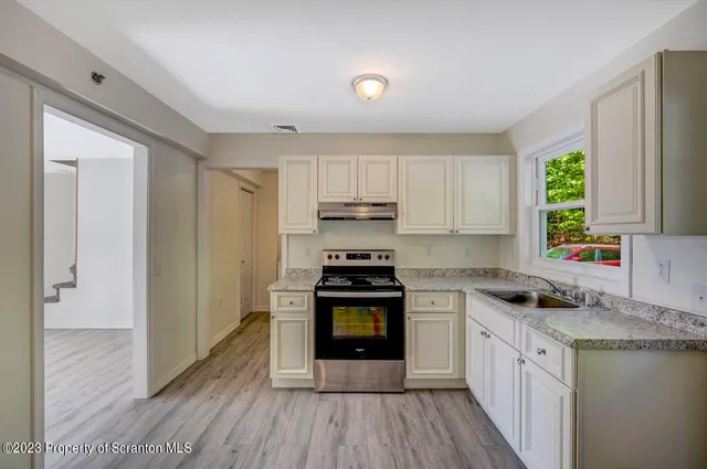 a kitchen with a stove a sink and a microwave