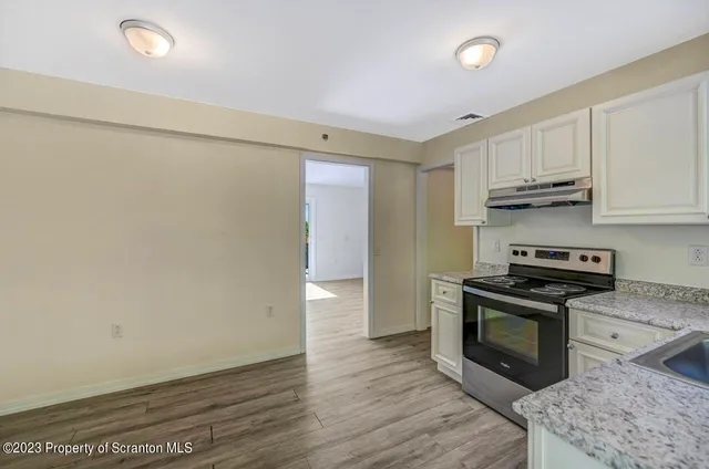 a kitchen with granite countertop a stove and a refrigerator
